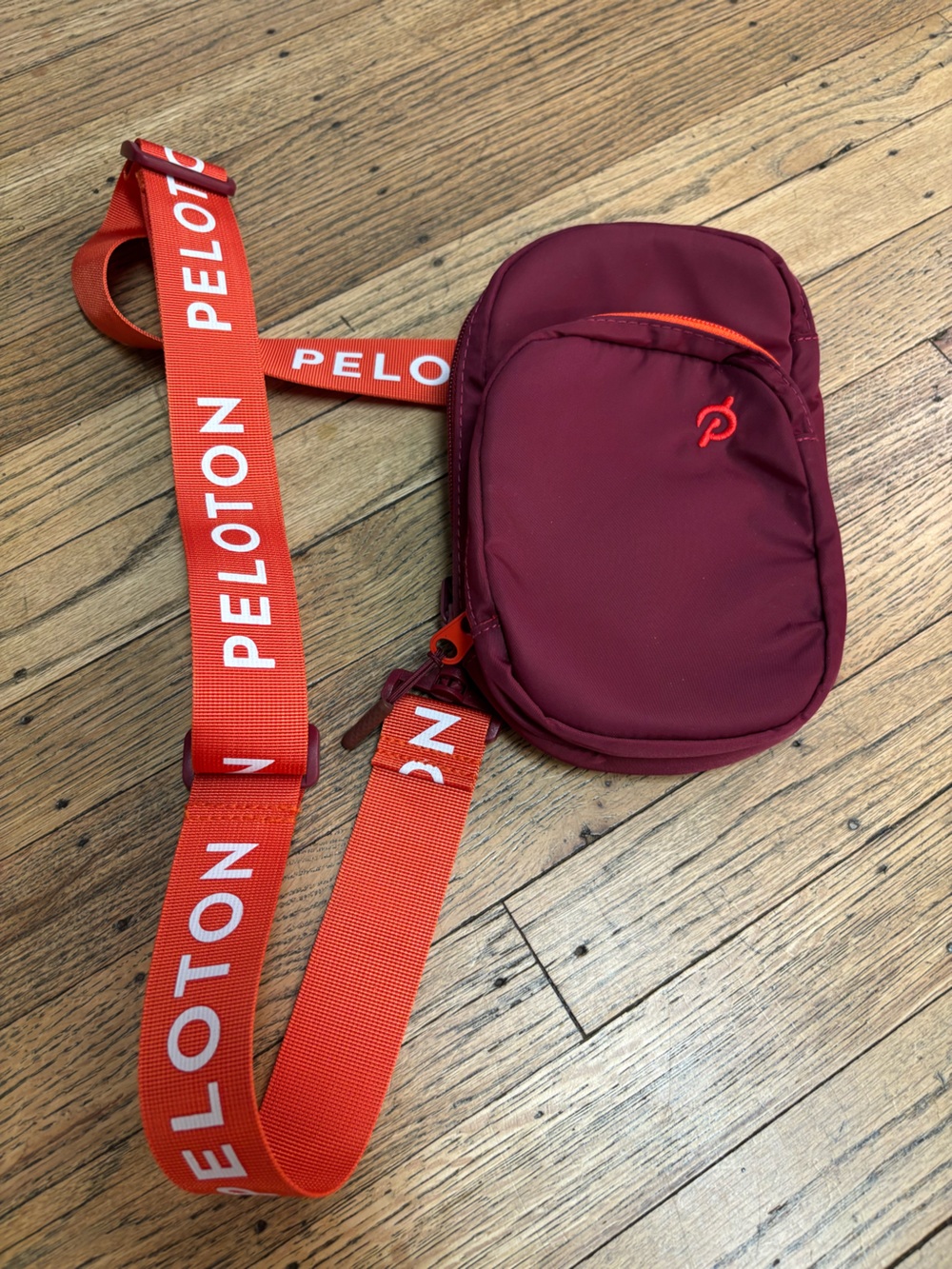 Peloton Maroon Sling Bag with Bright Orange Logo Strap